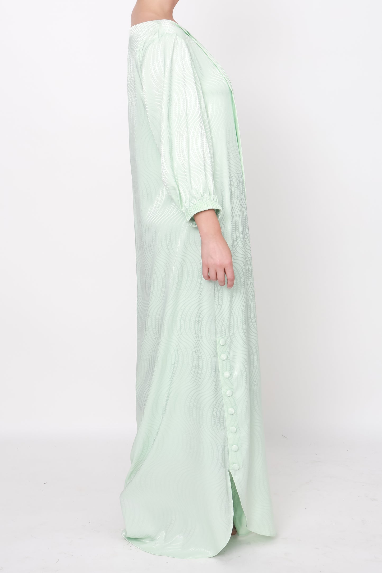 Exquisite green silk dress with pleated front detailing from the right shoulder, subtle white pearl and bugle bead band, and playful puff sleeves