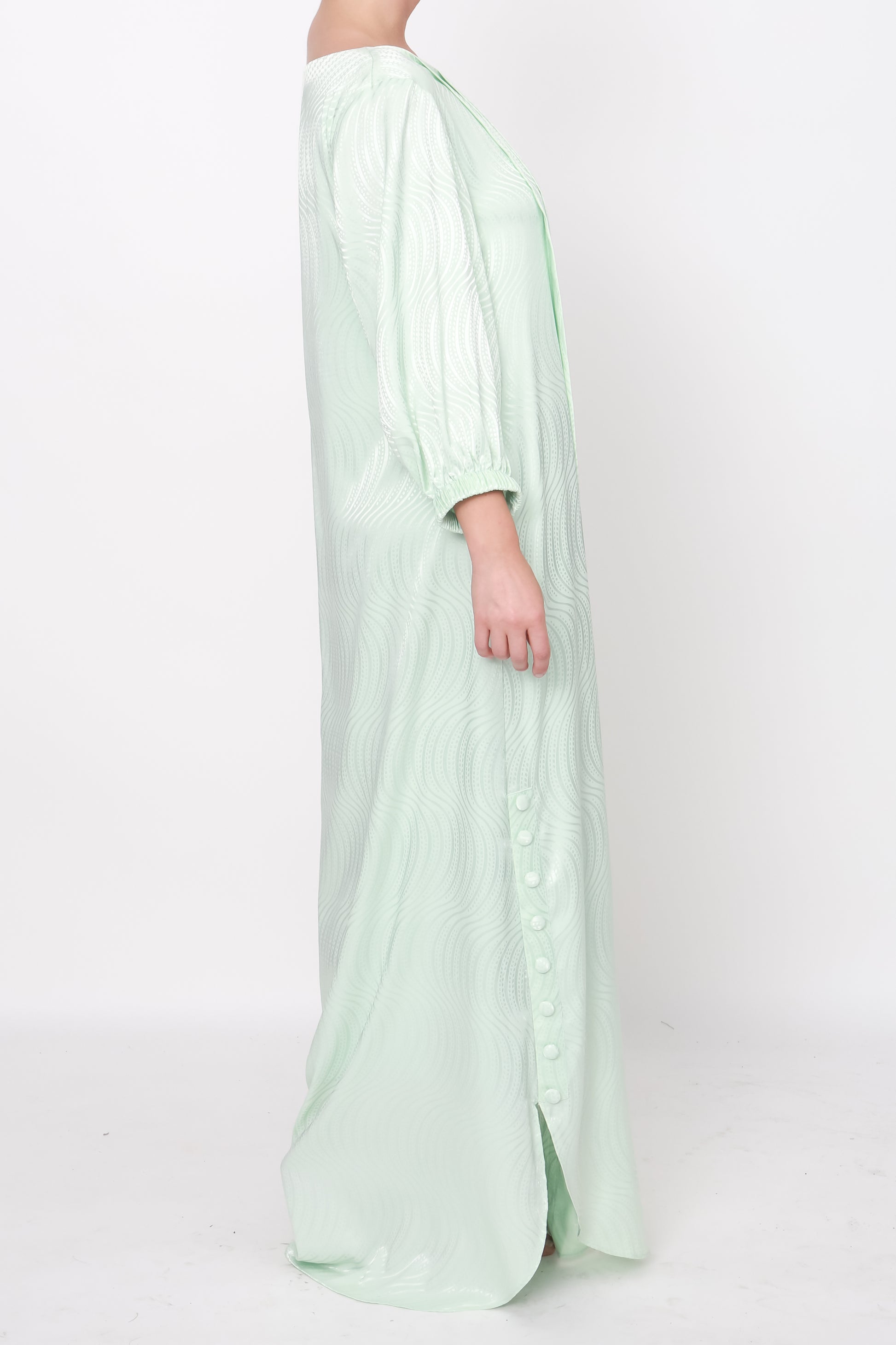 Exquisite green silk dress with pleated front detailing from the right shoulder, subtle white pearl and bugle bead band, and playful puff sleeves