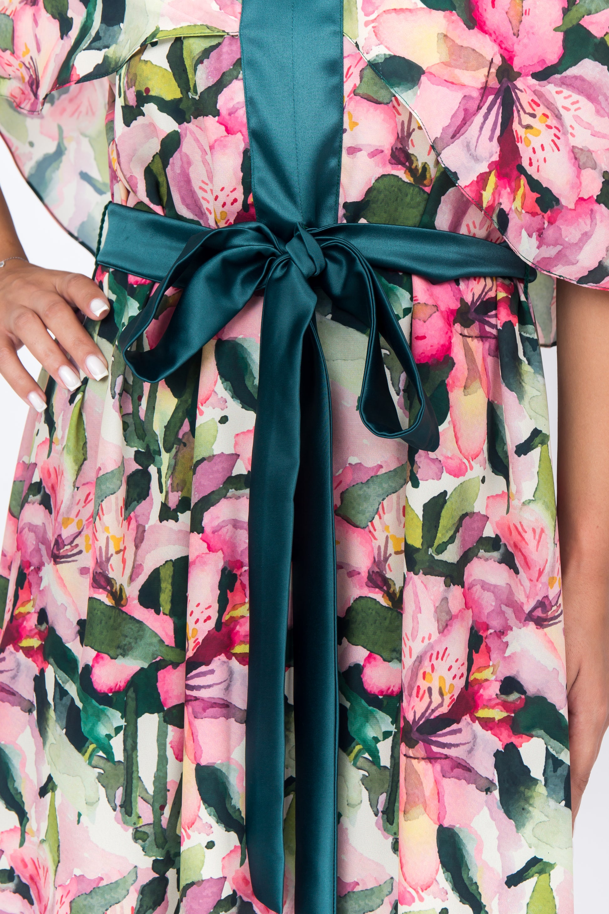 Close up of front of silk dress with a unique cap sleeve design and contrasting green accents with bow on front of the dress