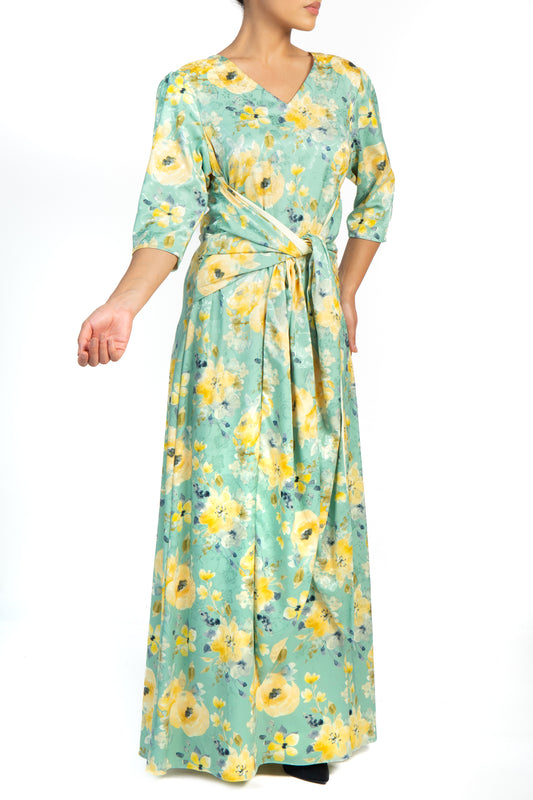 Woman wearing green and yellow floral silk dress with wide band tie waist