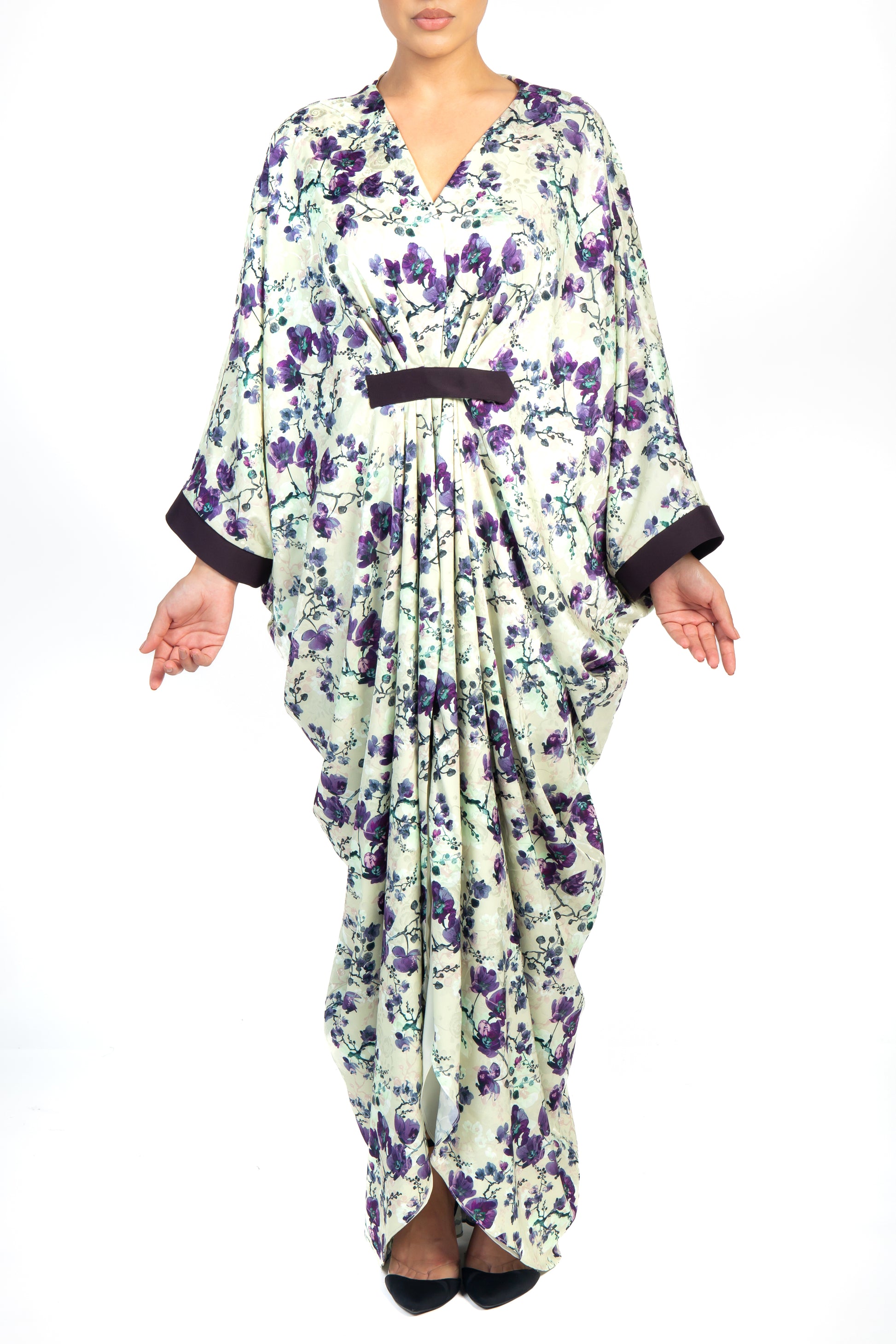 Front view of a woman wearing a floral kaftan that is purple, black and white