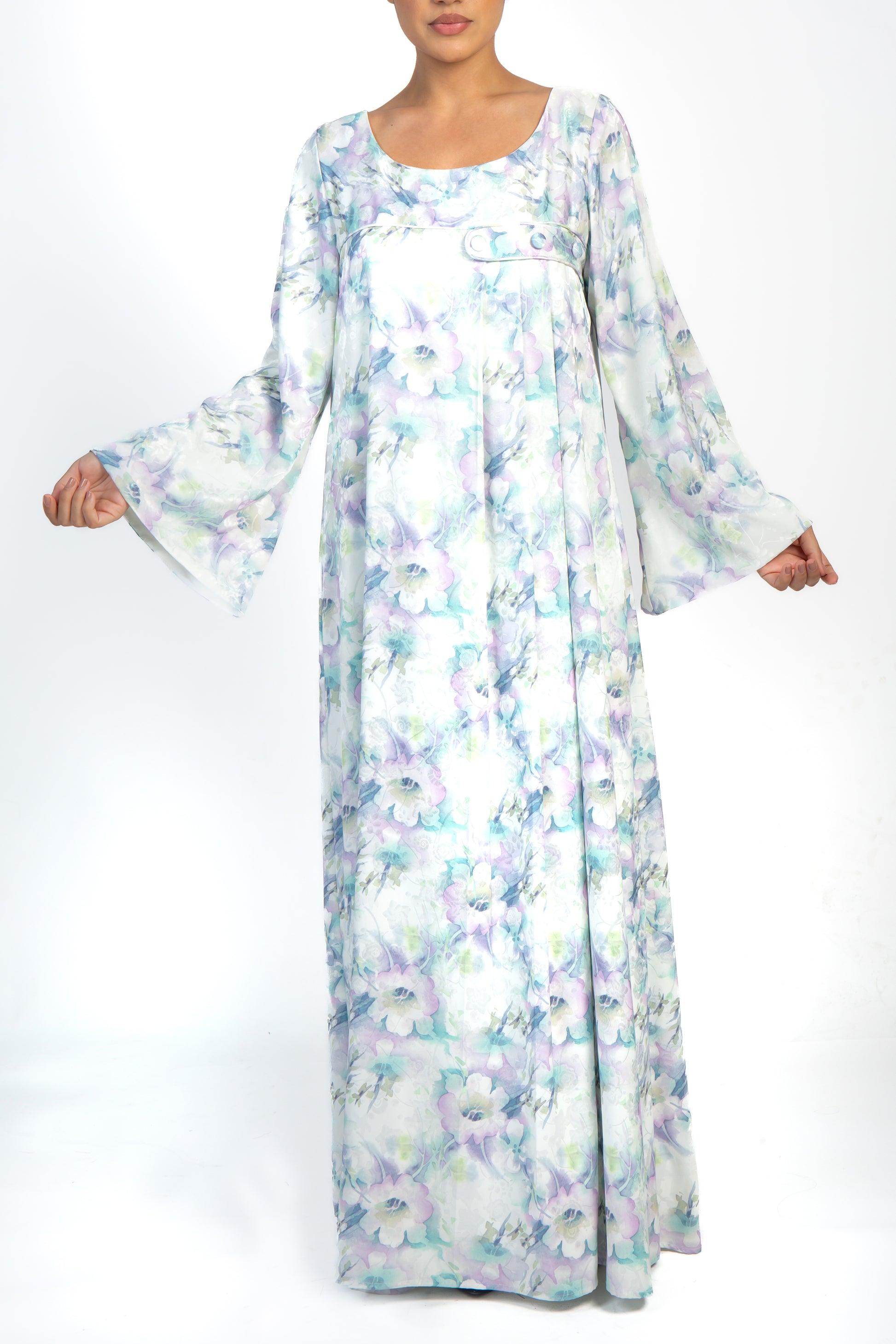 Loose-fitting ivory and lilac print silk dress with round neckline, long sleeves, and pleating on the left side. Finished with a simple band and covered buttons. Light and airy material perfect for any occasion.